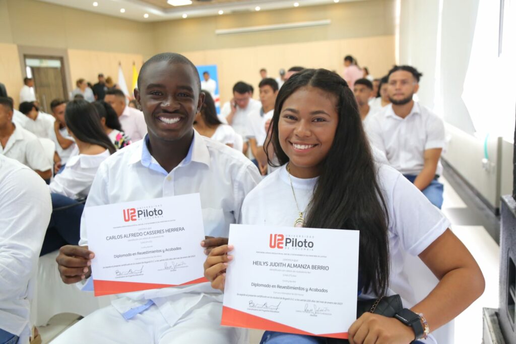 dos jóvenes sonrientes muestra su certificado de formación en construcción.